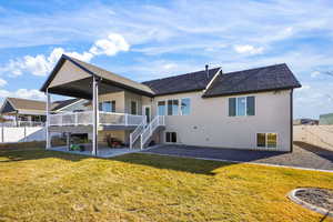 Rear view of property featuring a patio area, a fenced backyard, stucco siding, roof with shingles, and a wooden deck