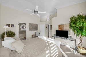 Carpeted bedroom featuring ornamental molding, a high ceiling, connected bathroom, and a ceiling fan