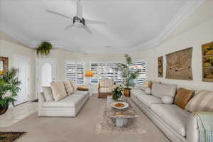 Carpeted living area featuring ceiling fan, a tray ceiling, and tile patterned flooring