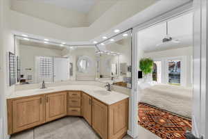 Ensuite bathroom with double vanity, recessed lighting, and a ceiling fan