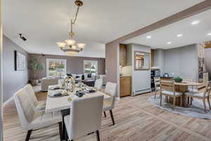 Dining space with light wood-style floors, a chandelier, and a baseboard heating unit