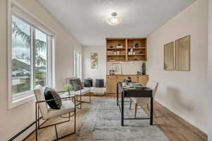 Office featuring a baseboard heating unit and light wood-type flooring