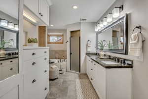 Full bath featuring double vanity, a garden tub, a shower stall, recessed lighting, and a baseboard radiator