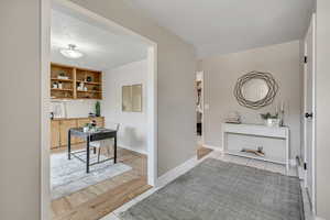 Hall featuring light wood-type flooring and a baseboard heating unit
