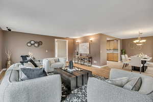 Living room with light wood-type flooring and hanging lights