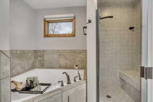 Bathroom featuring a shower stall and a garden tub