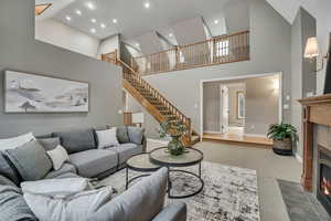 Living room featuring a tile fireplace, carpet flooring, recessed lighting, and lofted ceiling