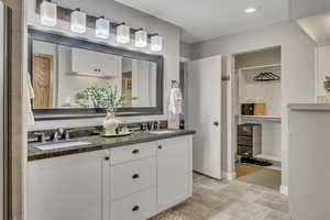 Bathroom with a spacious closet, double vanity, and recessed lighting
