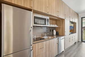 Kitchen featuring stainless steel appliances, light wood finish cabinets, modern cabinets, and open shelves