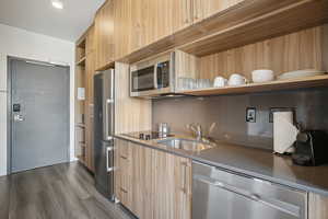 Kitchen featuring open shelves, stainless steel appliances, modern cabinets, and dark wood finished floors