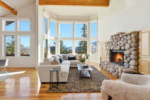 Living room featuring light wood-style flooring, a stone fireplace, and a mountain view