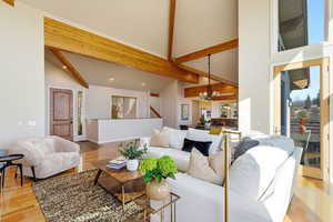 Living room featuring light wood-style flooring, hanging lights, healthy amount of natural light, and lofted ceiling