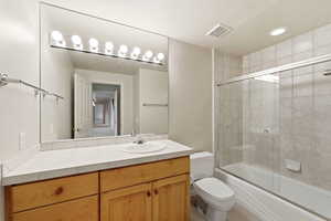 Full bathroom with enclosed tub / shower combo, vanity, and recessed lighting