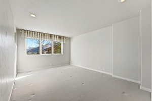 Carpeted empty room with baseboards and recessed lighting