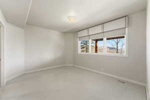 Carpeted empty room featuring baseboards