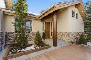 Property entrance with stone siding and stucco siding