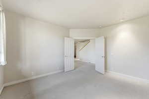 Carpeted empty room featuring baseboards