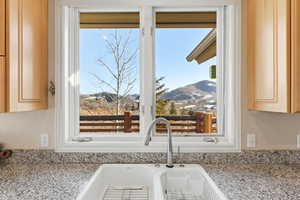 Kitchen view of light stone counters and light wood finish cabinets