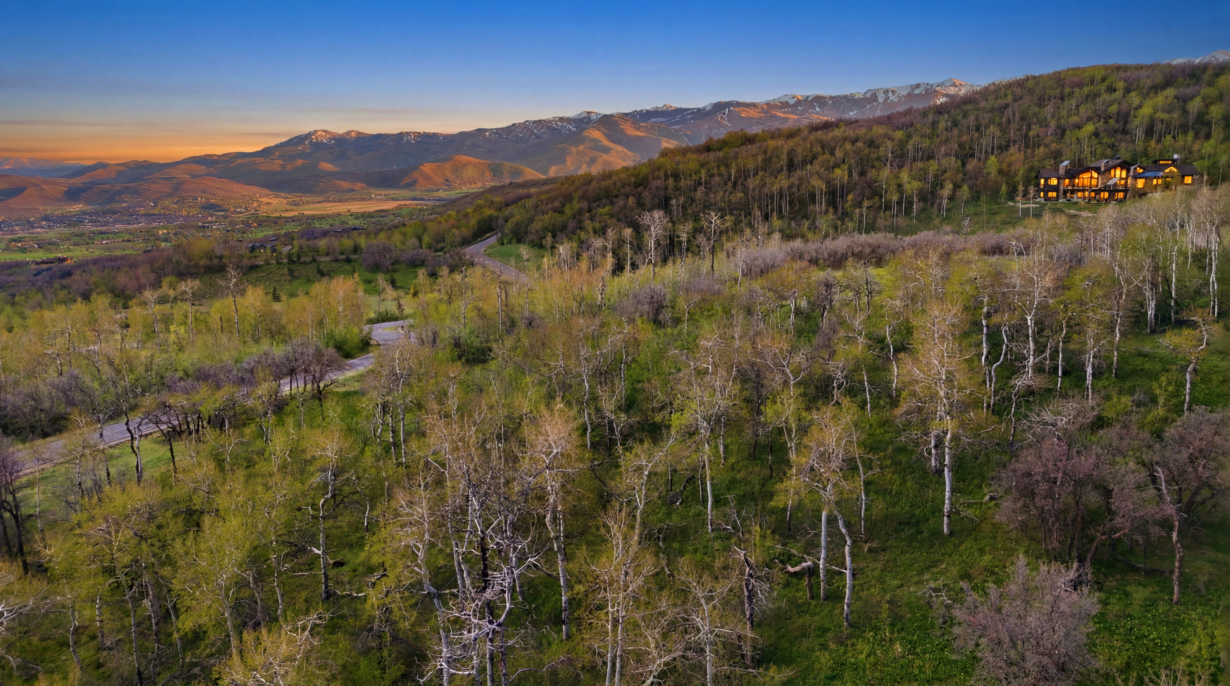 Expansive mountain property featuring a large residence with multiple gables and a stone facade
