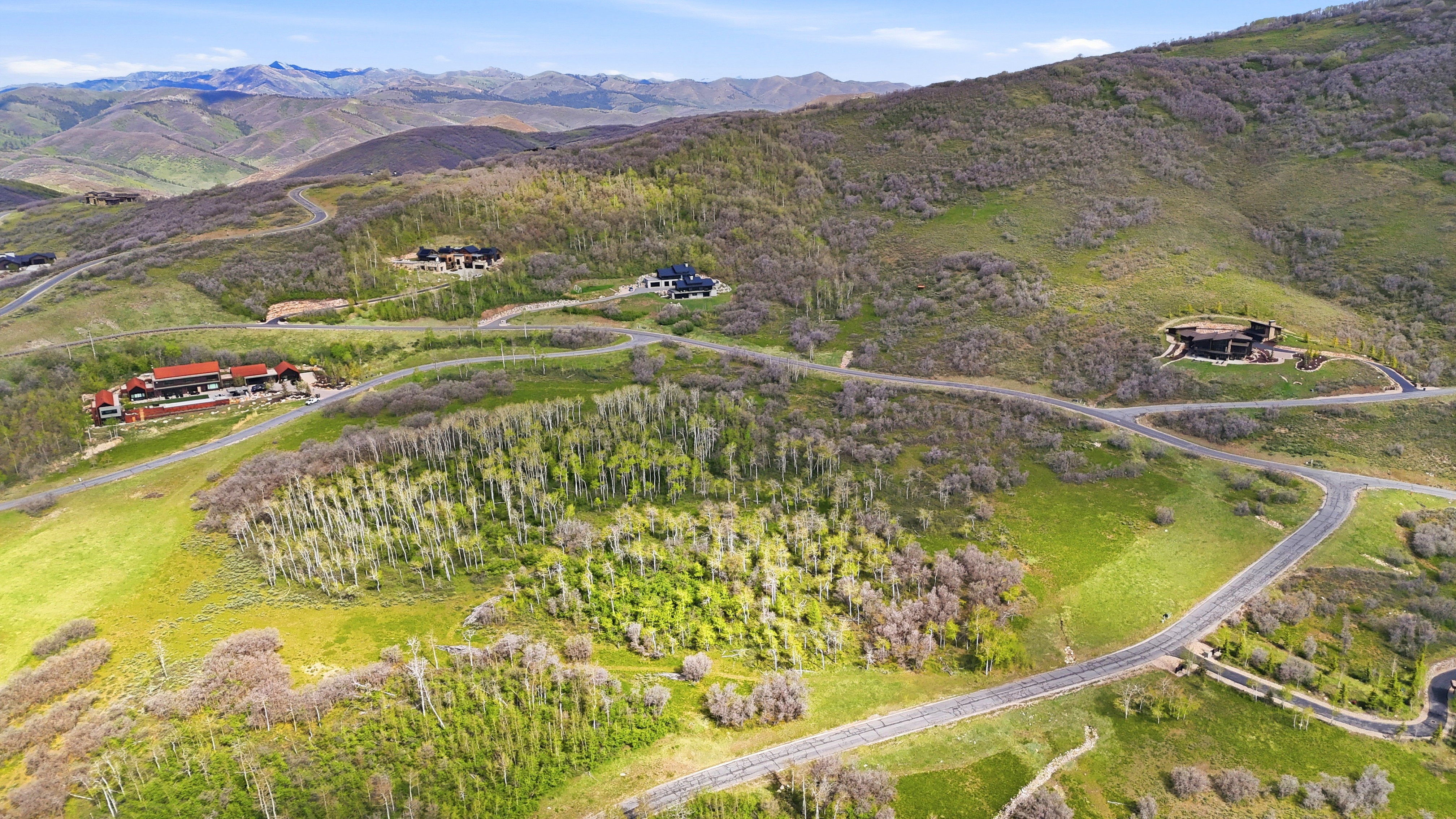 Expansive mountainous terrain featuring scattered residences and winding paved roads