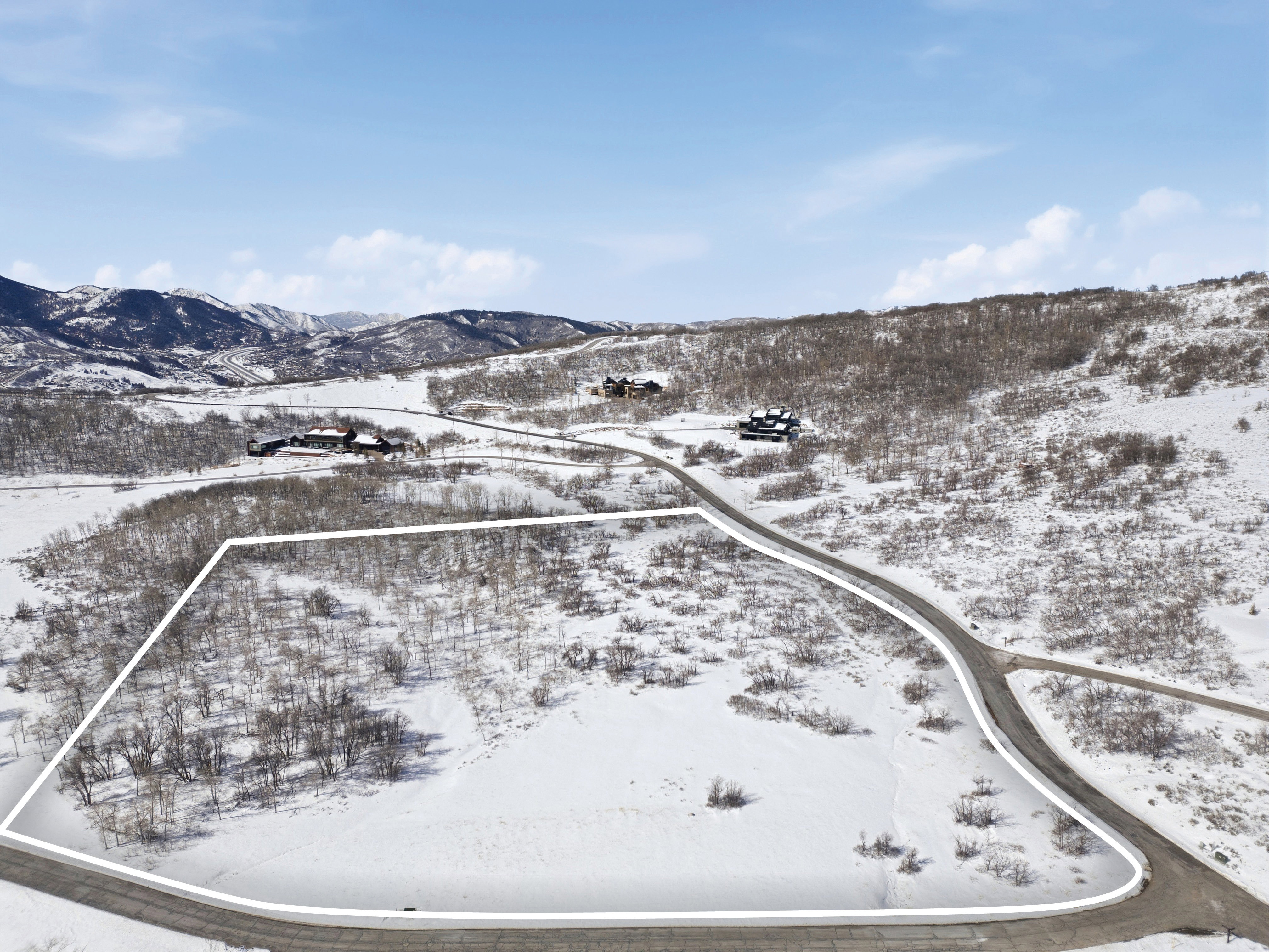 Snowy aerial view with property parcel outlined and a mountain view
