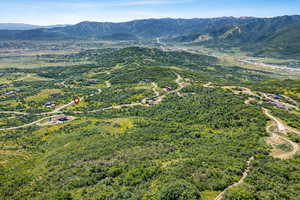 Aerial view of property and surrounding area with a mountainous background
