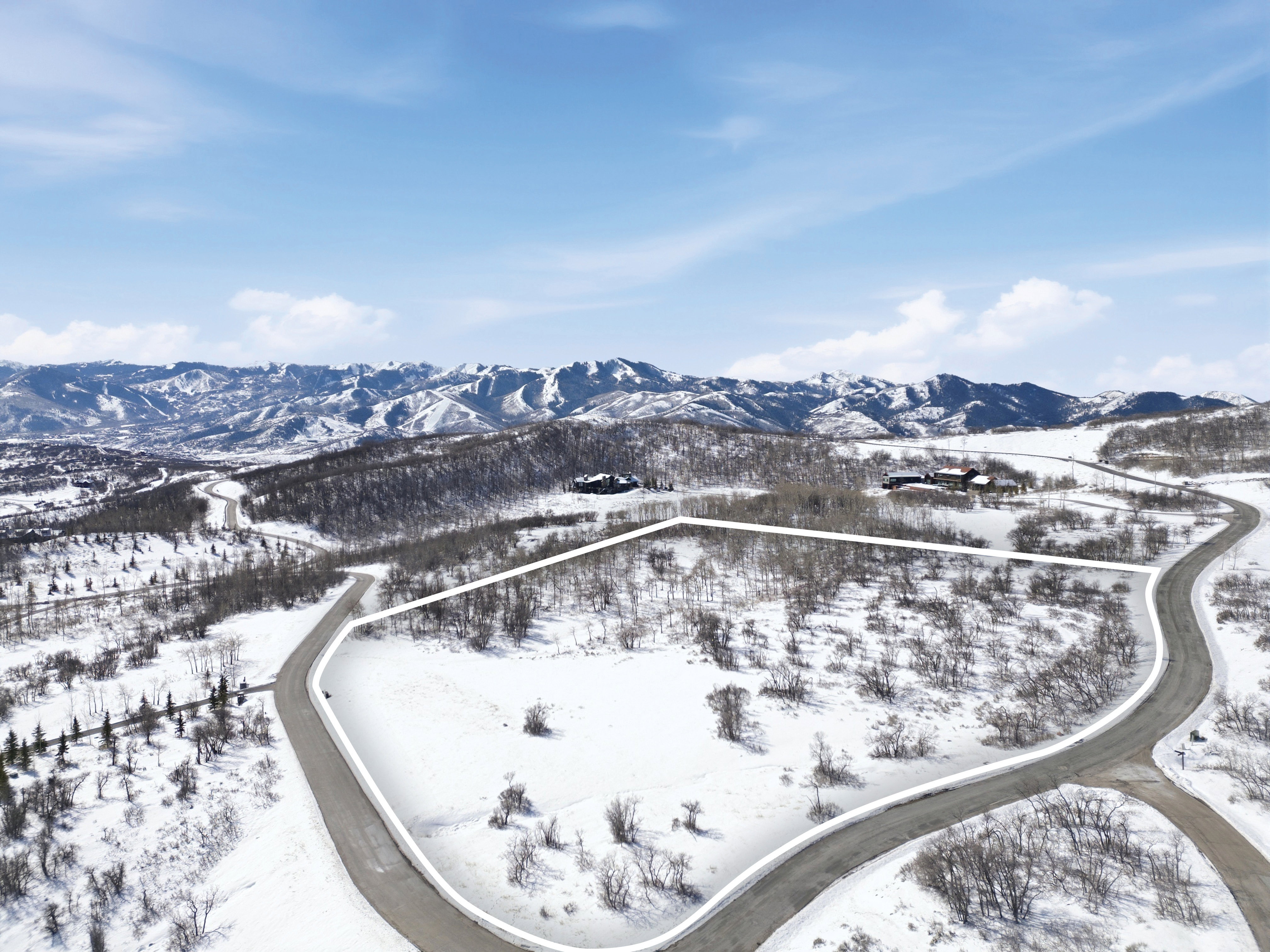 Snowy aerial view with a mountain view and property boundaries highlighted
