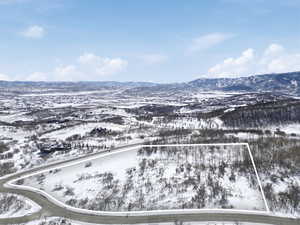 Snowy aerial view featuring a mountain view and property boundaries highlighted