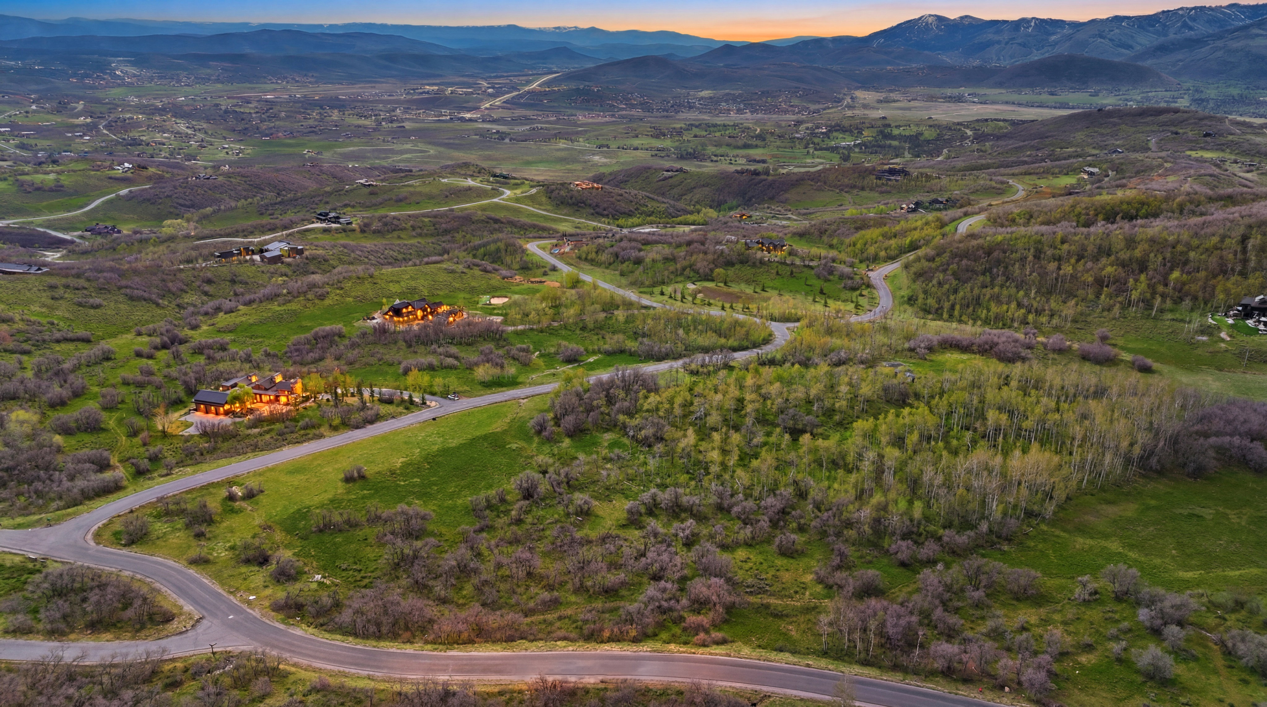 Expansive mountain landscape featuring paved roads and residential properties