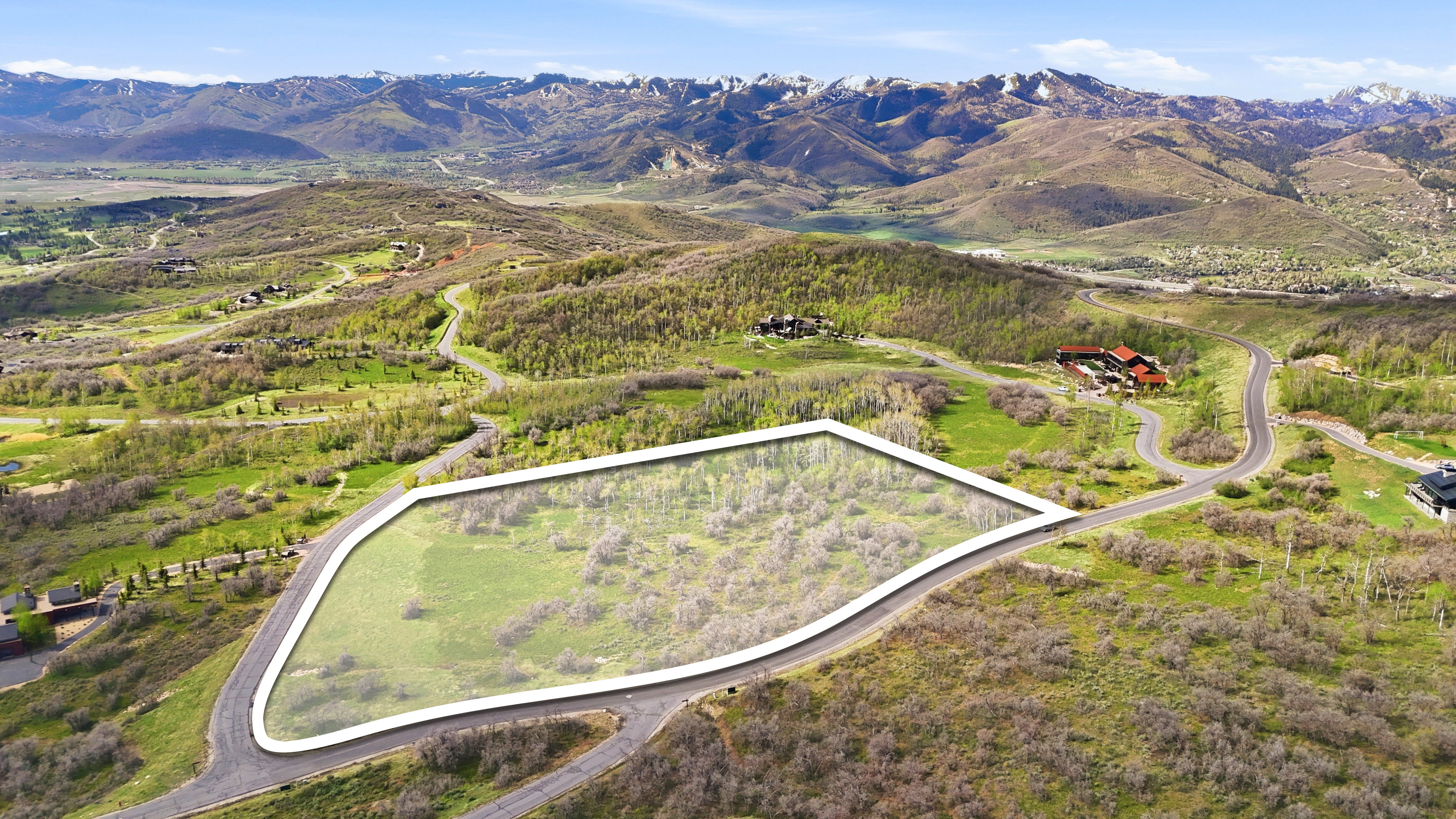 Expansive lot featuring a natural, undeveloped landscape framed by a paved roadway