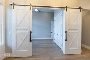Corridor with a barn door and light wood-style flooring