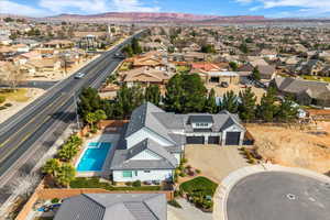 Aerial perspective of suburban area with a mountain backdrop and a pool