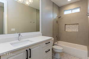 Bathroom with shower / bath combination, vanity, and light tile patterned flooring