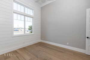Spare room with wood finished floors and crown molding