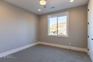 Carpeted empty room featuring a ceiling fan and recessed lighting