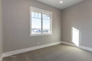 Carpeted empty room featuring baseboards and recessed lighting