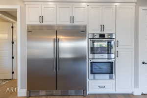 Kitchen featuring stainless steel appliances, white cabinetry, and light wood finished floors