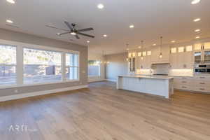 Kitchen featuring glass insert cabinets, white cabinetry, a ceiling fan, hanging lights, and backsplash
