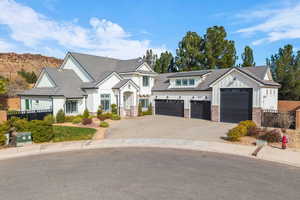 Modern inspired farmhouse with board and batten siding, driveway, a standing seam roof, and an attached garage