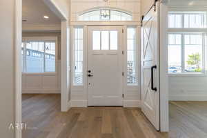 Entryway featuring a barn door, light wood-style floors, and plenty of natural light