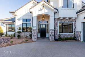 Entrance to property featuring brick siding, board and batten siding, and a tiled roof