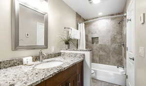 Bathroom featuring vanity and shower / bath combination with curtain