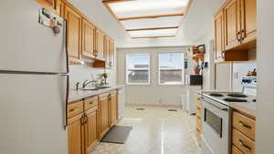 Kitchen featuring white appliances, light countertops, and light floors