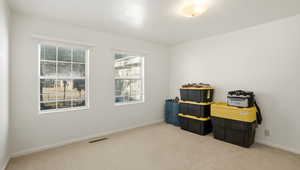 Misc room with light colored carpet and baseboards