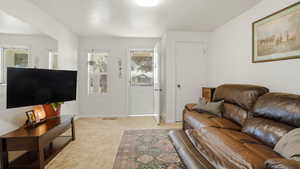 Living area with light colored carpet and baseboards