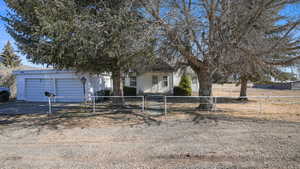View of front of house with concrete driveway, a fenced front yard, a gate, and a garage
