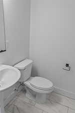 Bathroom featuring marble finish flooring and toilet