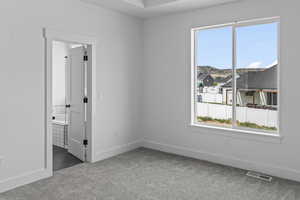 Empty room featuring baseboards and dark colored carpet