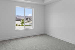 Carpeted spare room featuring baseboards and a mountain view