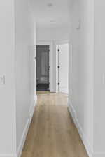 Hall with light wood-type flooring and baseboards